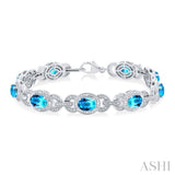 7x5 MM Oval Shape Blue Topaz and 1/10 ctw Round Cut Diamond Semi Precious Bracelet in Sterling Silver